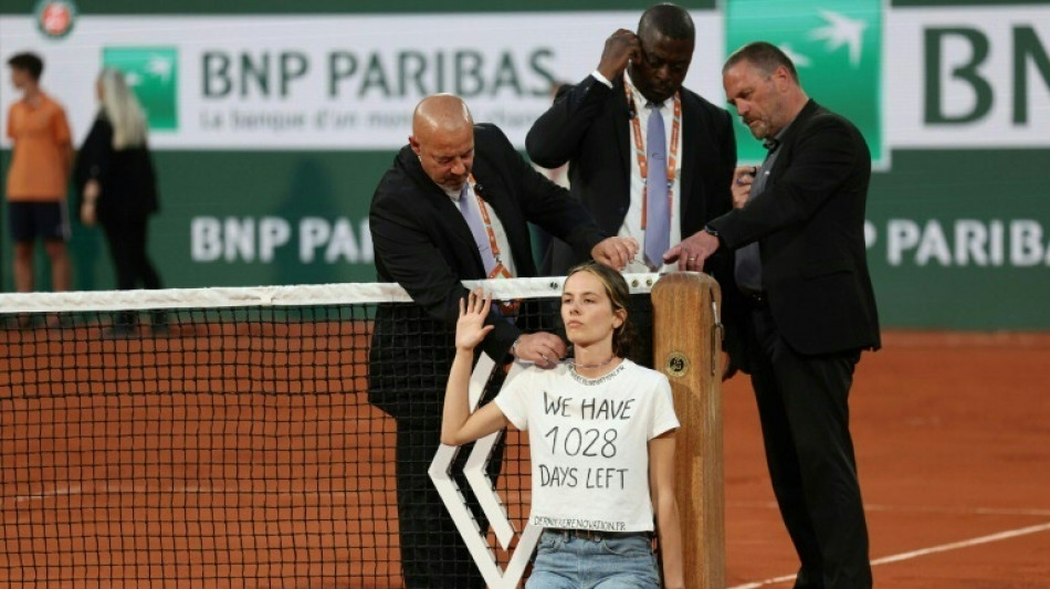 French Open semi-final interrupted as protester ties herself to net